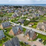 Aerial view of houses with green areas and sea view
