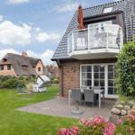 House with balcony, terrace and garden. Traditional houses in the background.