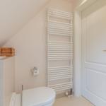 Bathroom with toilet, heater, and door