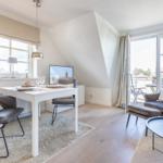 Living room with dining table, armchairs, and balcony access.