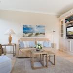 Wohnzimmer mit Sofa, Sessel, Fernseher und Wandbild.