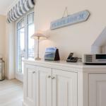 Wohnzimmer mit Fenster, Schrank und Wandbild