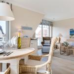 Essbereich mit Tisch und Stühlen, Wohnbereich mit Sofa und Fenster
