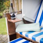 Blue-and-white lounge chair with drink and towel in the garden