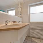 Bathroom with sink, mirror, and window with blinds.