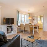 Living and dining area with TV, dining table, and windows.