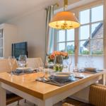 Dining room with table, chairs, and window view of house and garden.
