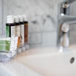 Sink with faucet and small bottles for toiletries.