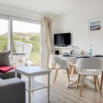 Living and dining area with TV and view of the dunes.