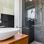 Badezimmer mit Dusche, Waschbecken und Fenster