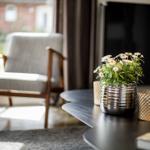 Ein Wohnzimmer mit Sitzgelegenheit, Tisch und Blumenarrangement.
