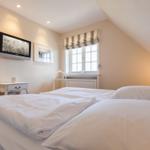 Bedroom with double bed, window, TV, and nightstand.