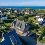 Village with thatched houses and view of the sea.