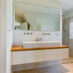 Badezimmer mit Waschtisch, Spiegel und Dusche