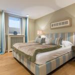 Schlafzimmer mit Bett, Nachttisch und Fenster