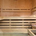 Holzsauna mit Sitzbänken und Eimer