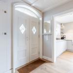 House with entrance door, closet, and view into the kitchen.
