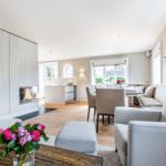Living and dining area with fireplace, seating, and windows.