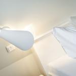 Living room with white bed and wall lamp