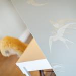 Wall with bird motifs and wooden floor in the background.
