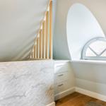Bedroom with marine theme, wooden staircase, and arched window