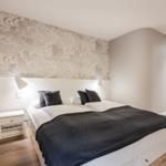 Bedroom with bed, nightstand, and patterned wall.