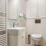 Bathroom with sink, toilet, and heater.