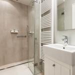 Shower cabin with glass enclosure, sink, and heater.