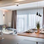 Essbereich mit Tisch, Stühlen und Fenster. Küche im Vordergrund.