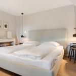 Schlafzimmer mit Bett, Nachttisch und Wandlampen.