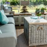 A gray sofa with turquoise cushions and a woven table.