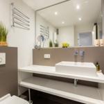 Bathroom with sink, mirror, and toilet.