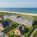 Holiday complex near the beach with multiple buildings and green areas.