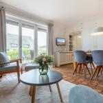 Wohn- und Essbereich mit Terrasse, Holzmöbeln und Terrakottaboden.