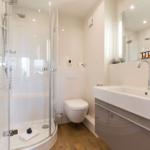 Badezimmer mit Dusche, Toilette und Waschbecken.