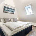 Schlafzimmer mit Doppelbett, Fenster und Wandbild