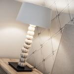 Table lamp with ball base on nightstand beside chair