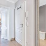 Hallway with white doors, bathroom, and another room visible.