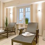 Two lounge chairs with towels near a window with striped walls and plants.