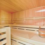 Wooden sauna with benches and bucket. Wooden walls and ceiling.