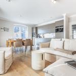Living and dining area with modern kitchen and wooden floor.