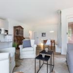 Living and dining area with sofa, armchairs, and wooden floor.