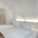 Schlafzimmer mit Bett, Wandbild und schrägem Dach