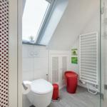 Badezimmer mit Dusche, Toilette und Fenster