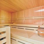 Sauna mit Holzbanken und Eimer für Wasser