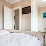 Schlafzimmer mit Bett, Fernseher und Kleiderschrank