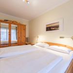 Schlafzimmer mit Holzbett, Kleiderschrank und Wandbild.