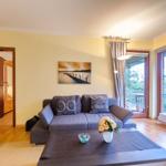 Wohnzimmer mit Sofa, Tisch und Blick auf Balkon