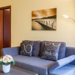 Ein grauer Sofa mit Kissen, Wandbild und Stehlampe im Wohnzimmer.
