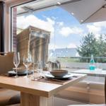 Dining table for four with view to terrace and sunshade.